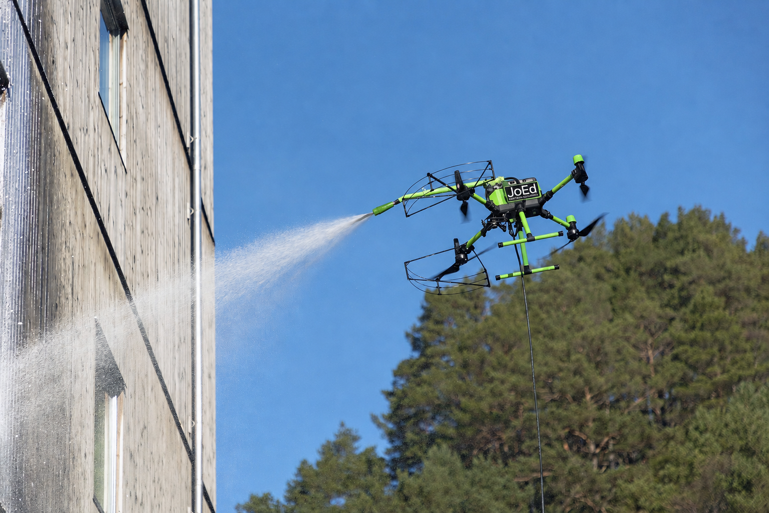 JoEd drone power-washing glass building facade